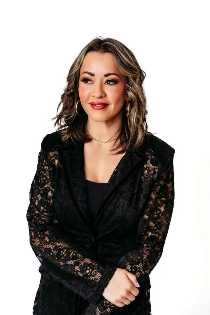 Lexi Yoo NP smiling studio portrait in a black lace blazer