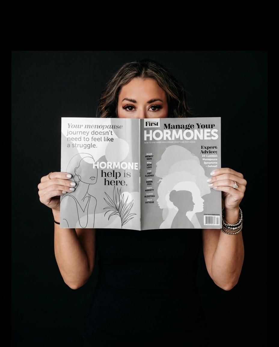 Lexi Yoo, nurse practitioner - Holding 'Manage Your Hormones' magazine over lower face, black top, dark background