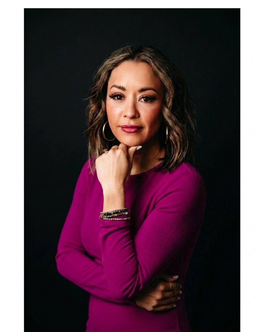 Lexi Yoo, nurse practitioner - Magenta long-sleeve top, chin resting on fist, black background - moody general portrait
